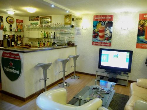 - un bar avec une télévision et un ordinateur dans la chambre dans l'établissement Hotel Alexander, à Perpignan