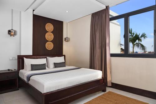 a bedroom with a bed and a large window at Hotel Five.S in Kampot