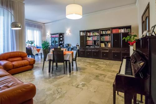 a living room with a table and chairs and a piano at Villa Lazzari B&B Tra i due Mari in Maglie