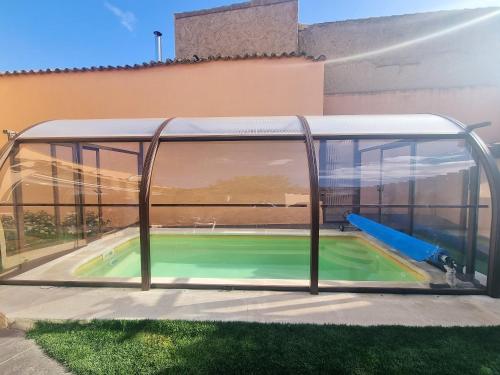 a swimming pool in a glass house with a slide at Charming villa in Pajares de la Lampreana with private pool in Pajares de la Lampreana