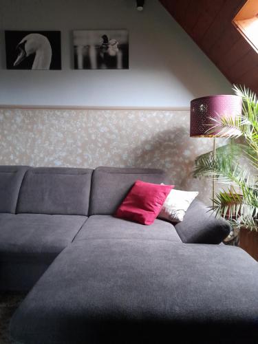 a couch with two pillows on it in a living room at Agave Apartman in Velence