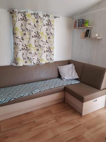 a couch with a pillow on it in a room at Luxueuze stacaravan in Bredene met eigen terras en tuintje (425) in Bredene
