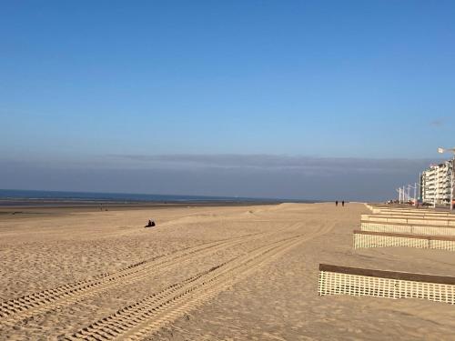 a beach with people sitting on the sand at My Fair - Koksijde in Koksijde