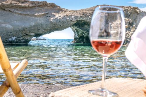 a glass of wine sitting on a table next to the water at AQUA HOUSE in Pachaina