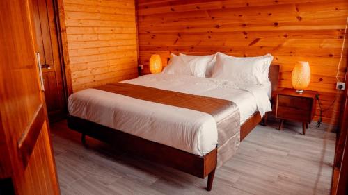 a bedroom with a bed in a wooden room at شاليهات رانس الريفية in Jeddah