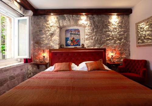 sypialnia z dużym łóżkiem i kamienną ścianą w obiekcie Luxury villa Kalalarga in the center of the town w Makarskiej