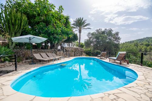 una piscina con dos sillas y una sombrilla en Villa Historica, en San Miguel de Balansat