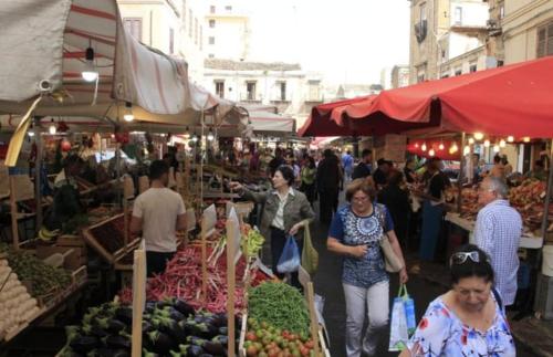 un grupo de personas caminando por un mercado al aire libre en Afrodite appartamento Ballarò, en Palermo