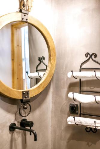 a round mirror on a wall with towels at AQUA HOUSE in Pachaina