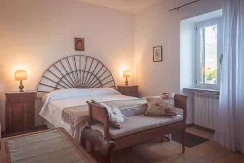 a bedroom with a bed and a bench with two lamps at Agriturismo Querceto in Frazione Mocaiana