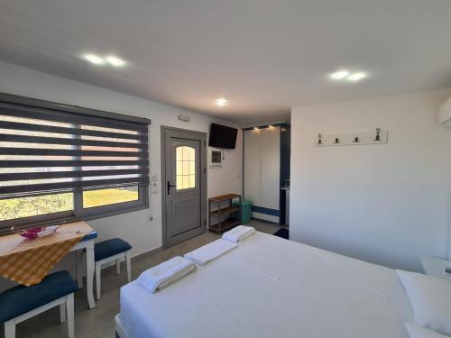 a bedroom with two beds and a table and a window at Martini Vacation Home in Sarandë