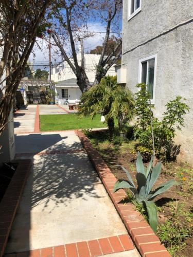 
a garden area with a tree and a building at Rest Haven Motel in Los Angeles
