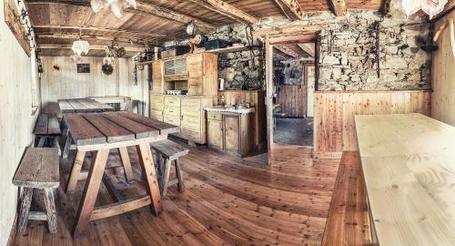 eine Küche mit Holzböden und einem Holztisch in der Unterkunft Rifugio Serot in Rundscheinberg