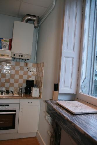 une cuisine avec un comptoir et une fenêtre dans l'établissement Appartement T4 - Centre de Luchon - 6 pers - Ski - Randonnée - Cure, à Luchon