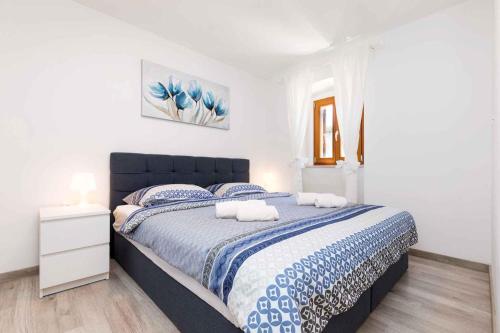Schlafzimmer mit einem großen Bett mit blauer und weißer Bettwäsche in der Unterkunft Holiday home in Veli Losinj 40979 in Veli Lošinj