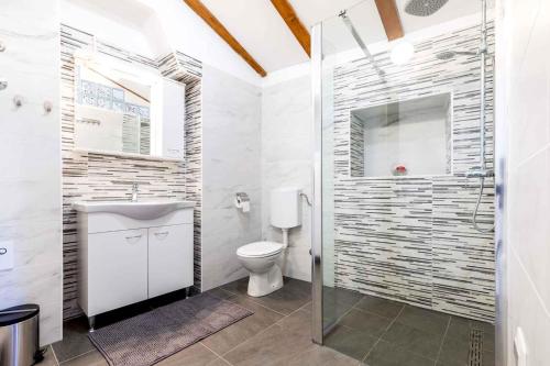 Un baño con inodoro y ducha de cristal. en Holiday home in Veli Losinj 40979, en Veli Lošinj