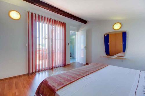 マリ・ロシニにあるHoliday home in Mali Losinj 36244の大きなベッドと大きな窓のある寝室