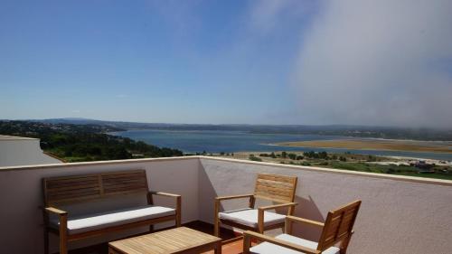 two chairs on a balcony with a view of the water at Casa Feliz Obidos Lagoon and sea view in Foz do Arelho