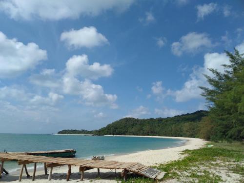 a picnic table on a beach next to the ocean at Coto Center Homestay in Dao Co To