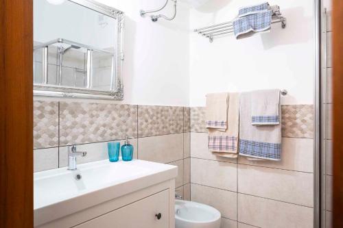 une salle de bain avec un lavabo, des toilettes et un miroir dans l'établissement Studio in Porto Santa Margherita 40284, à Porto Santa Margherita