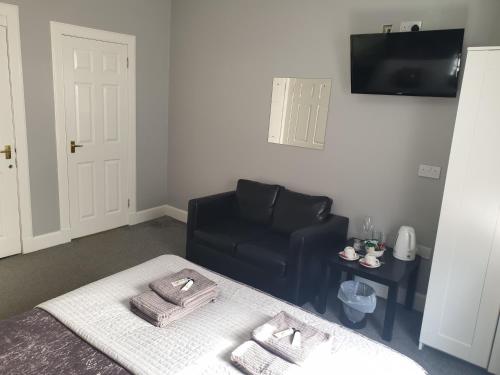 a living room with a black chair and a table at cellardyke en-suite rooms in Cellardyke
