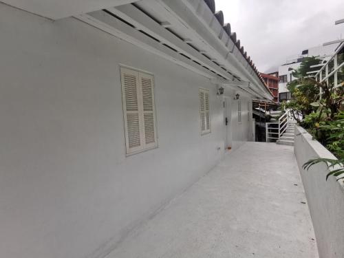 a white building with a window on the side of it at Ample Villa 小希臘民宿 in Ruifang