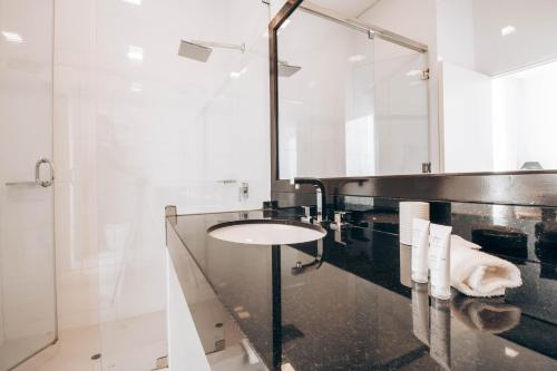 a bathroom with a sink and a mirror at Suites del Bosque Hotel in Lima