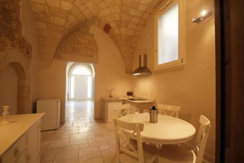 cocina y comedor con mesa blanca y sillas en La Suite di Martina, en Lecce