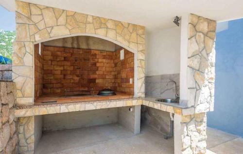 a stone kitchen with a sink and a brick wall at Apartments Karlobag - Velebit Riviera 39571 in Karlobag