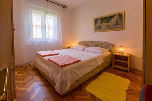 een slaapkamer met een bed met 2 kussens en een raam bij Apartment in Crikvenica 39213 in Crikvenica