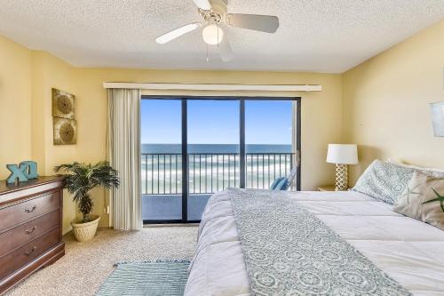a bedroom with a bed and a large window at Commodore Resort #703 by Book That Condo in Panama City Beach