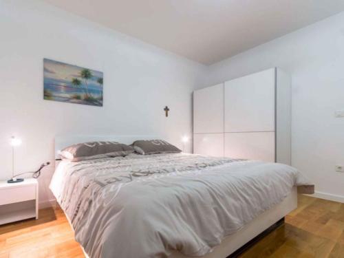 - une chambre avec un grand lit et un mur blanc dans l'établissement Apartment in Njivice/Insel Krk 35106, à Njivice