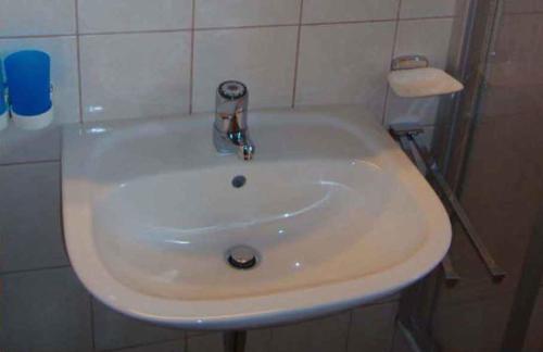 a white sink in a white tiled bathroom at Apartment in Kaltenbach - Zillertal 750 in Kaltenbach