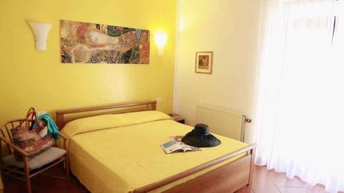 a bedroom with a bed with a hat on it at House and Apts. in Porto Azzurro 23632 in Porto Azzurro