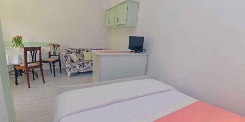 ein kleines Zimmer mit einem Bett und einem Tisch mit einem Computer in der Unterkunft Apartment in Veli Lošinj 36494 in Veli Lošinj