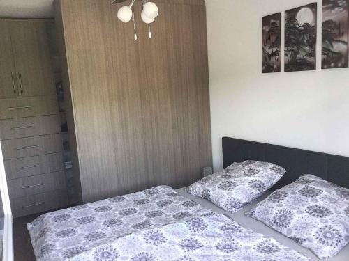 a bedroom with a bed and two pillows on it at Apartment in Balatonboglar 37959 in Balatonboglár