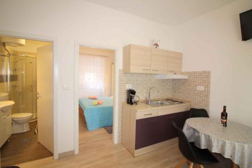Apartment in Porec/Istrien 36967 في بوريتش: مطبخ مع مغسلة وحمام مع سرير