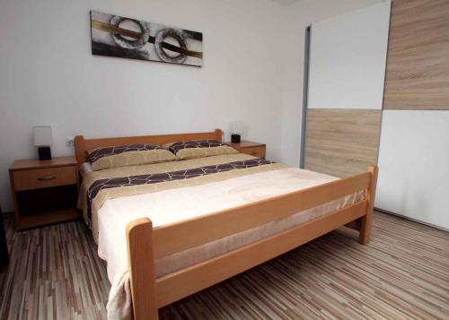 a bedroom with a bed with a wooden frame at Apartment in Vrbnik/Insel Krk 36872 in Vrbnik