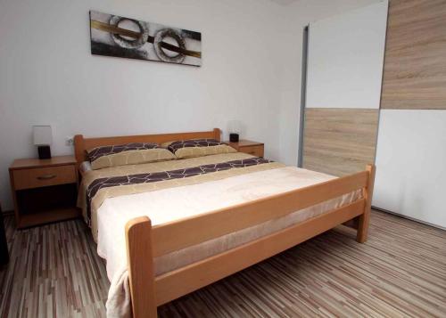 a bedroom with a bed with a wooden frame at Apartment in Vrbnik - Insel Krk 36872 in Vrbnik