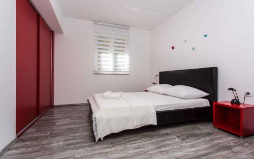 1 dormitorio con cama y mesa roja en Apartment in Vrbnik/Insel Krk 36800, en Vrbnik