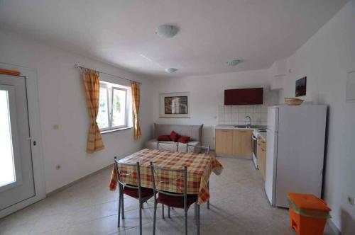 a kitchen with a table and a refrigerator at Apartment in Vrbnik/Insel Krk 36796 in Vrbnik