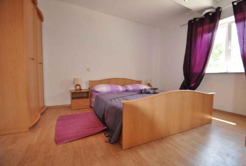 a bedroom with a bed with purple curtains at Apartment in Vrbnik/Insel Krk 36796 in Vrbnik
