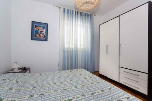 a bedroom with a bed and a dresser and a window at Apartments in Vrbnik/Insel Krk 36771 in Vrbnik