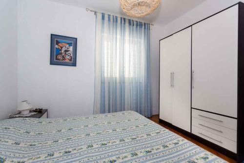 ein Schlafzimmer mit einem Bett, einer Kommode und einem Fenster in der Unterkunft Apartments in Vrbnik - Insel Krk 36771 in Vrbnik