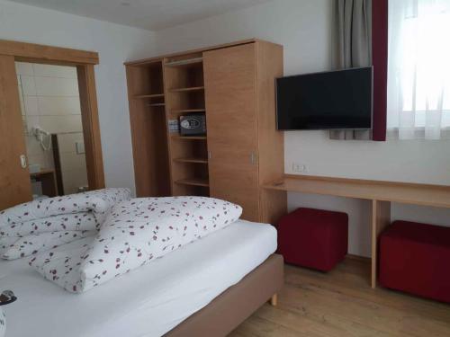 a bedroom with a bed with a tv on the wall at Apartments in Kappl/Paznauntal 36440 in Kappl