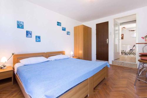 a bedroom with a large bed with a blue blanket at Studio in Vrbnik/Insel Krk 36776 in Vrbnik