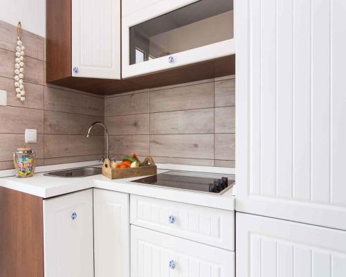 a kitchen with white cabinets and a sink at Apartment in Vrbnik/Insel Krk 36858 in Vrbnik