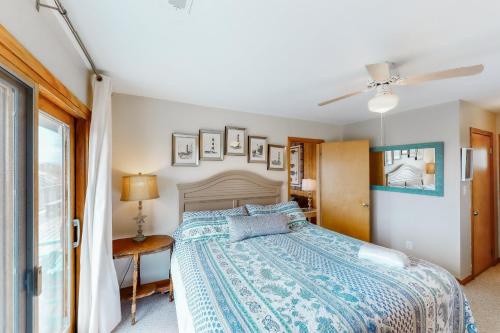 a bedroom with a bed with a blue bedspread at Hunter Haven #6HHH in Hatteras