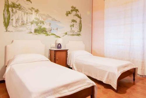 a bedroom with two beds and a painting on the wall at Holiday home in Portoferraio 23631 in Portoferraio