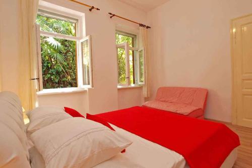 Pokój z łóżkiem i krzesłem oraz 2 oknami w obiekcie Apartment in Rabac 16989 w Rabacu